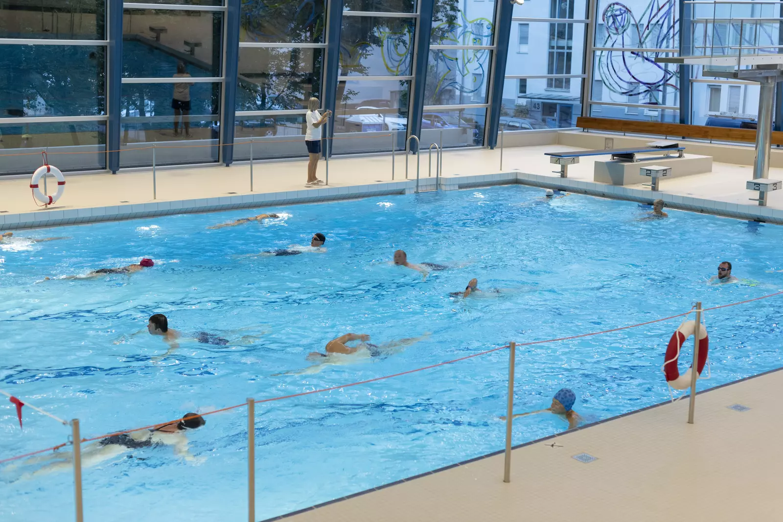 Einigen Badegäste schwimmen und trainieren im Mehrzweckbecken des Hallenbads Feuerbach.