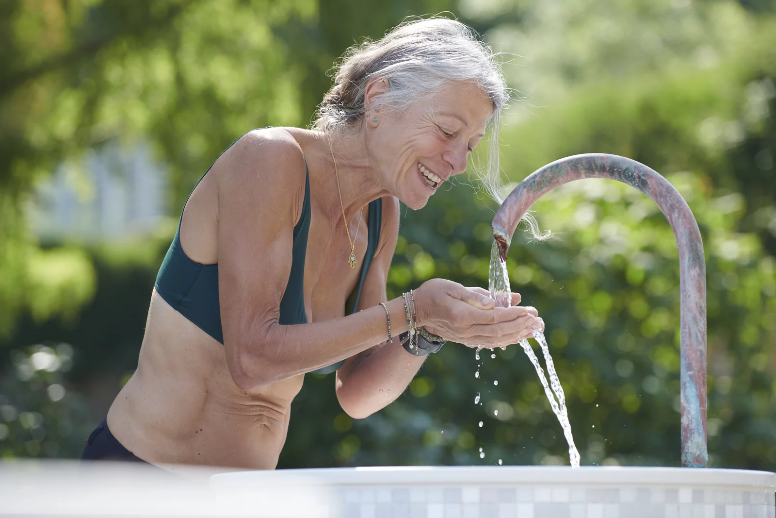 Frau am Trinkbrunnen im Mineralbad Berg Eine Frau trinkt das natürliche Mineralwasser aus einem Trinkbrunnen im Mineralbad Berg.