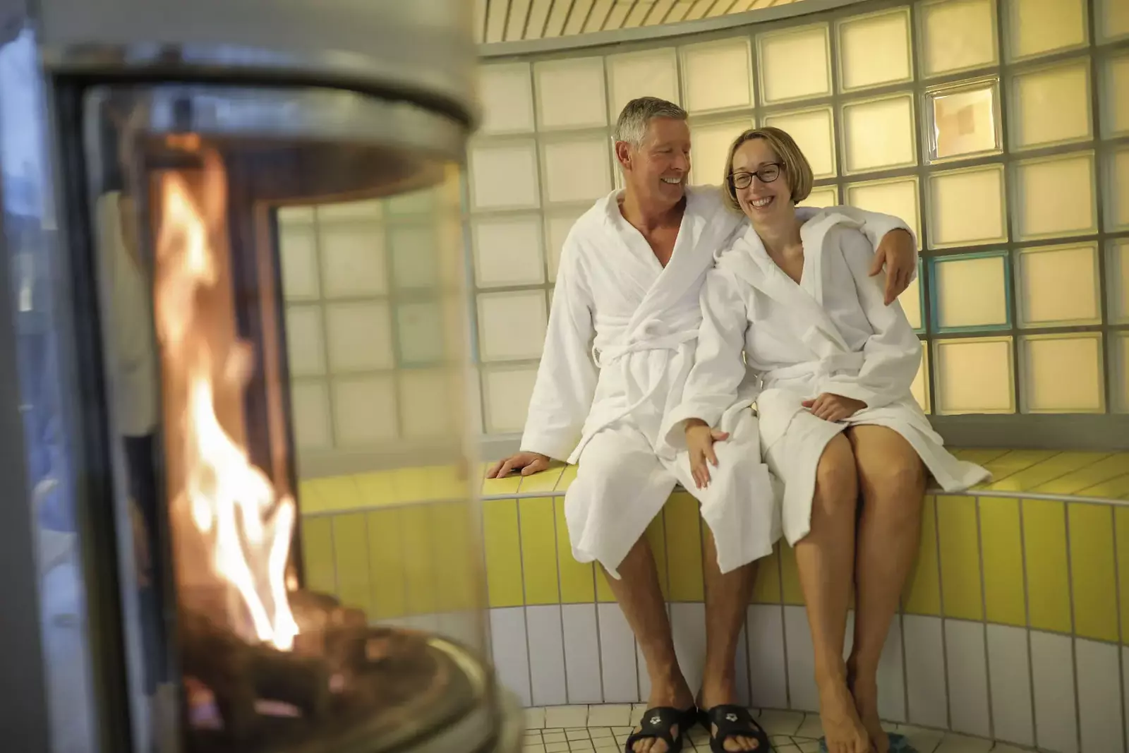 Ein Paar in weißen Bademänteln entspannt sich im Saunabereich im LEUZE.