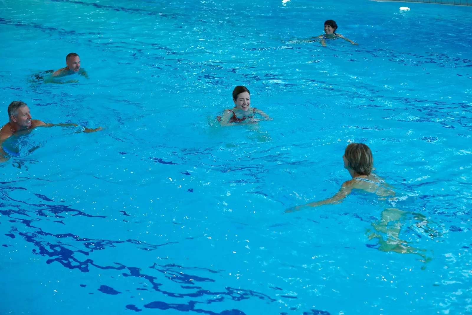 Einige Badegäste schwimmen im Innenbecken im Hallenbad Feuerbach.