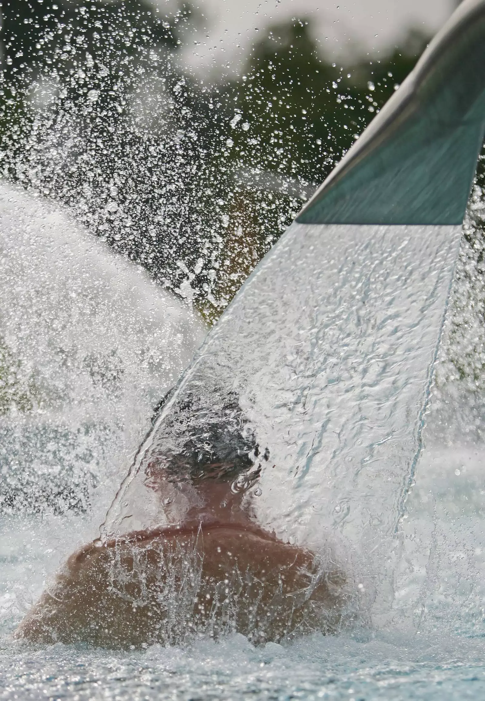 Ein Badegast steht mit dem Rücken unter dem Nackensprudler im Außenbecken im LEUZE