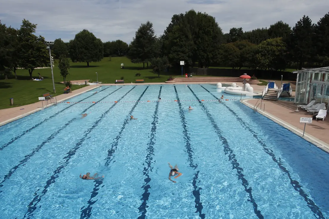 Einzelne Gäste schwimmen im Mehrzweck-Außenbecken ihre Bahnen im Freibad Möhringen.