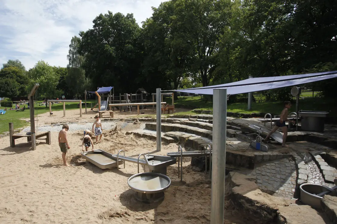 Kinderspielplatz mit Sandbecken und Schattenbereich im Freibad Rosental.