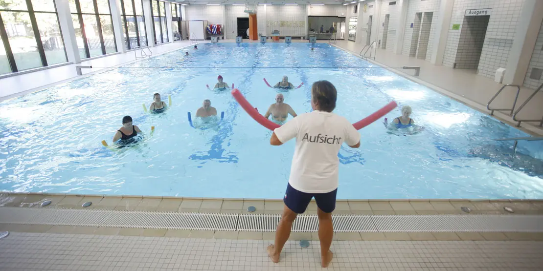 Eine Gruppe macht Wassergymnastik unter Anleitung vom Kursleiter im Hallenbad Plieningen.