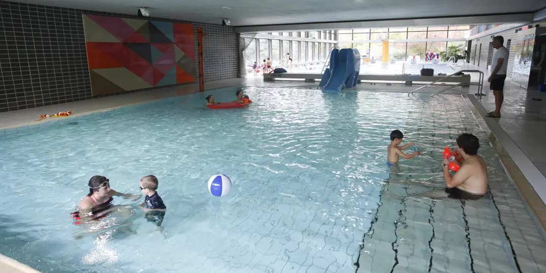 Kleinkinder in Begleitung von Erwachsenen im Nichtschwimmerbecken im Hallenbad Vaihingen.