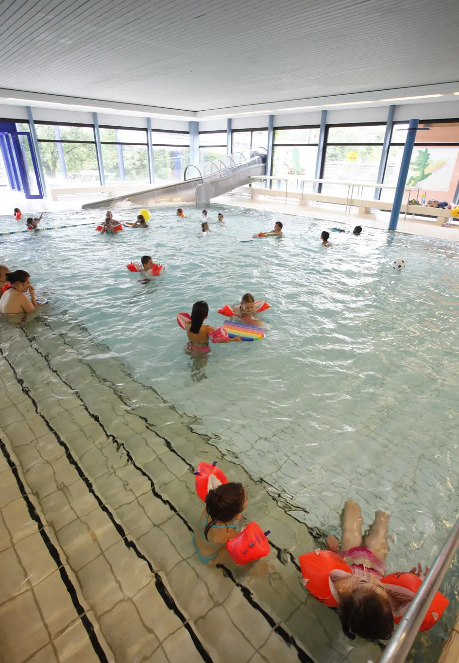 Kinder mit Schwimmflügeln planschen im Nichtschwimmerbecken im Hallenbad Zuffenhausen.